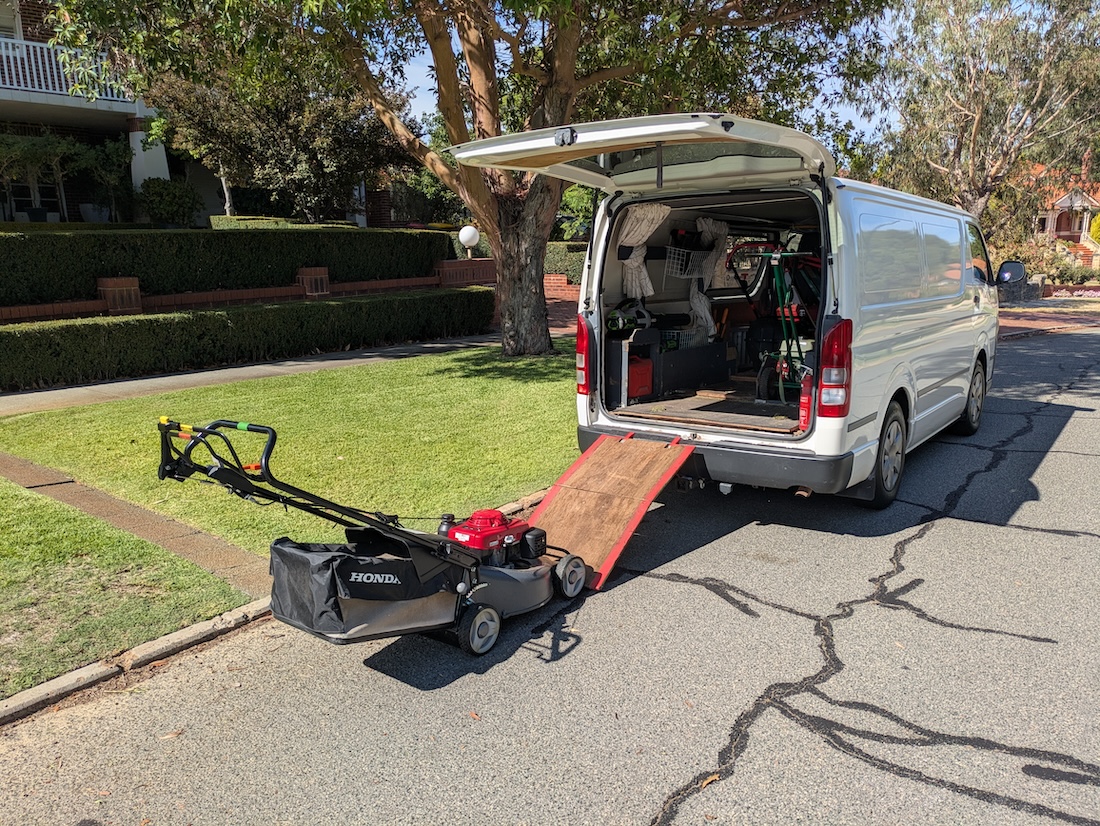 a finished lawn mowing job with paths and lawns both clean, as well as clean and well presented lawn mowing equipment and work van